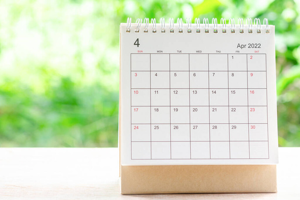 Квітень місяць, Календарний стіл 2022 для організатора планування і нагадування на дерев'яному столі з зеленим фоном природи
. - Фото, зображення