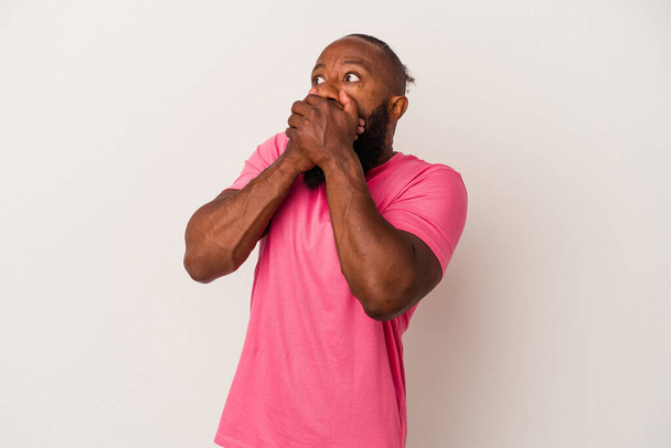 African american man with beard isolated on pink background thoughtful looking to a copy space covering mouth with hand. - Fotoğraf, Görsel