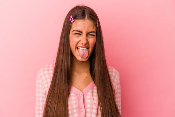 Молода біла жінка ізольована на рожевому тлі смішна і дружня, що стирчить язиком
. - Фото, зображення