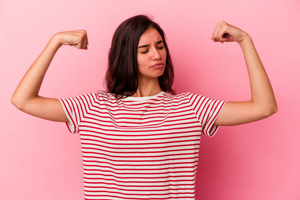 Young caucasian woman isolated on pink background showing strength gesture with arms, symbol of feminine power - Photo, Image