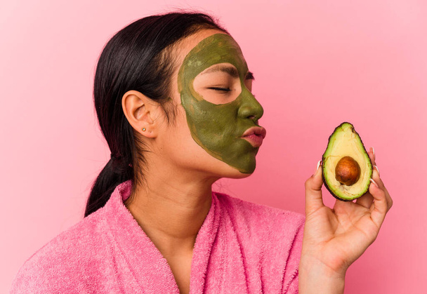 Young venezuelan woman wearing a facial mask isolated on pink background - Photo, Image