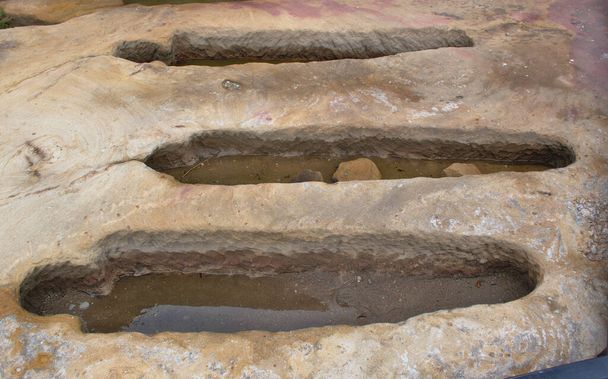Деталь трех антропоморфных гробниц, вырезанных из песчаника. Деревня Фемиэль-де-ла-Сьерра, Бургос, Испания. - Фото, изображение