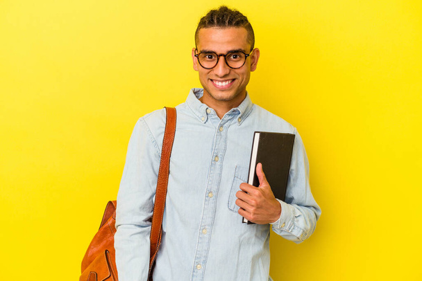 Junger venezolanischer Student isoliert auf gelbem Hintergrund glücklich, lächelnd und fröhlich. - Foto, Bild