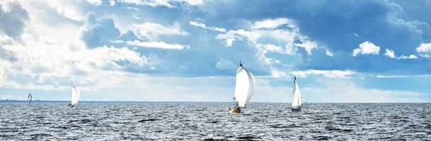 Purjehduspurjehdus regatta. Moderni purjevene kiiruhtaa aaltojen läpi. Dramaattinen taivas ennen ukkosta. Loistava pilvi. Pohjois-Saksa, Kiel - Valokuva, kuva