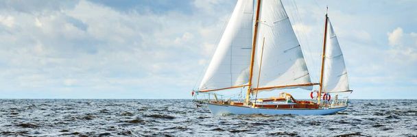 古い高価なヴィンテージ木製の帆船(ヨール)のクローズアップは、オープン海でセーリング。劇的な雲景。メイン州の海岸、米国 - 写真・画像