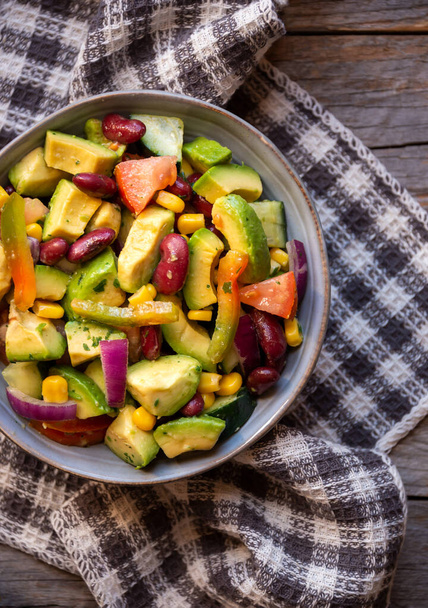 Sałatka awokado z innymi warzywami, pomidorami i kukurydzą. Zdrowe wegańskie jedzenie - Zdjęcie, obraz