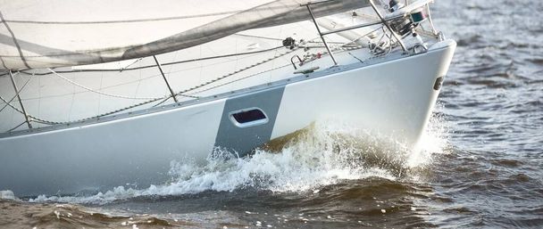 Zeiljacht regatta. Moderne zeilboot racen door de golven, close-up. Dramatische lucht voor het onweer. Geweldige wolkenkrabber. Noord-Duitsland, Kiel - Foto, afbeelding