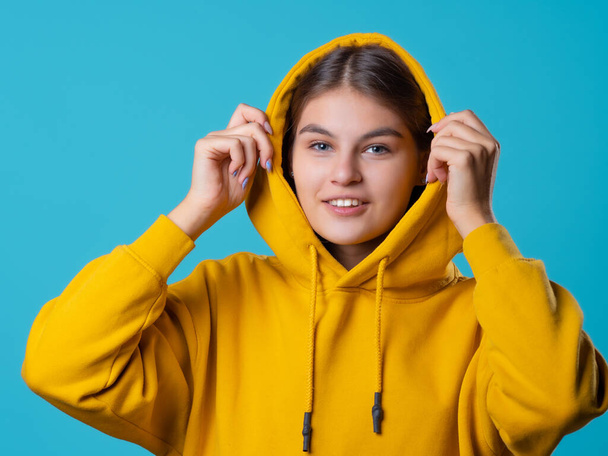 Beautiful young brunette with a hood on her head, youth oversize clothing style, - Fotografie, Obrázek