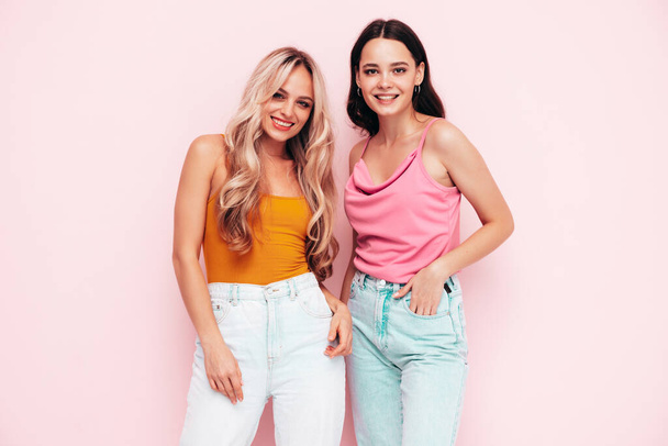 Two young beautiful smiling brunette hipster female in trendy summer clothes. Sexy carefree women posing near pink wall. Positive models having fun. Cheerful and happy - Fotoğraf, Görsel