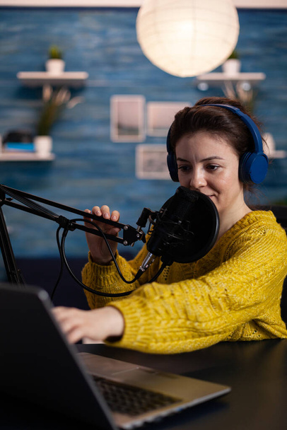Vrouw vlogger op zoek naar laptop lezen luisteraars vragen beantwoorden tijdens online podcast - Foto, afbeelding