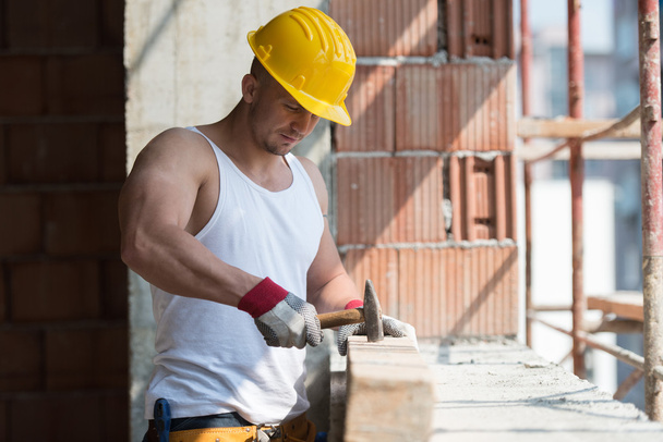 Hombre de construcción golpeando madera con martillo
 - Foto, Imagen