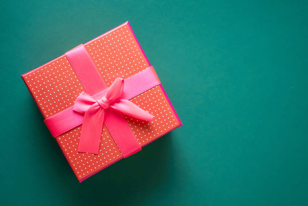 Red gift boxe on green background. Concept of holiday - Φωτογραφία, εικόνα