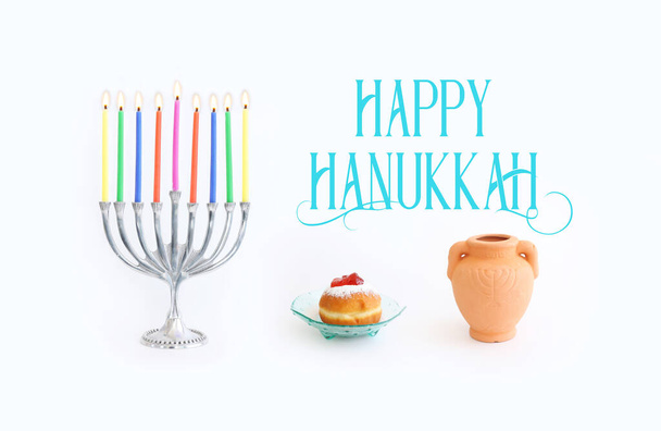 Religion image of jewish holiday Hanukkah background with menorah (traditional candelabra), doughnut and candles over white background - Photo, Image