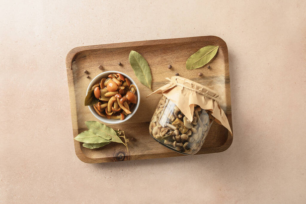 Pickled honey mushrooms served with bay leaf in bowl. - Foto, Imagem
