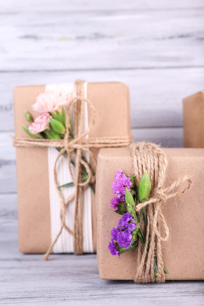 Beautiful gifts with flowers, on old wooden background - Foto, imagen