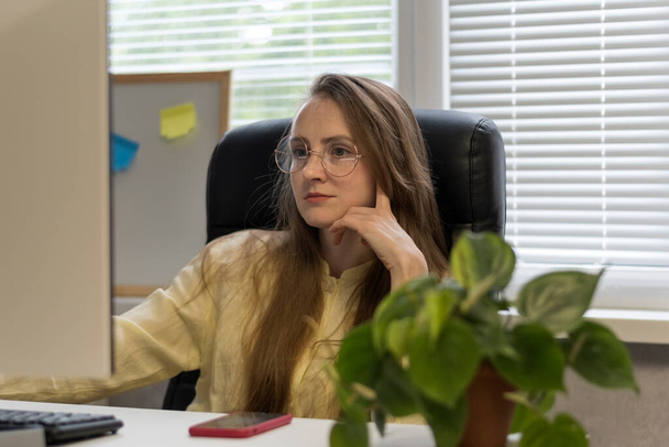 Young woman in glasses work in the office on pc. Successful designer working over the project - Photo, Image