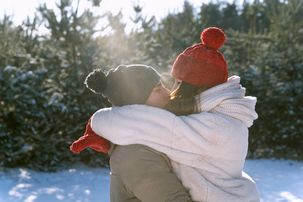 Pareja joven enamorada afuera en invierno besándose. Amantes felices en el bosque de invierno. - Foto, Imagen