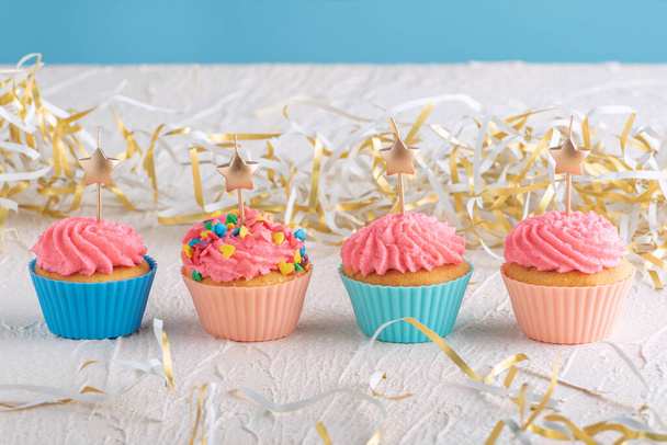 Muffins com creme de manteiga rosa cobertura com vela em forma de estrela. Comida de festa deliciosa - Foto, Imagem