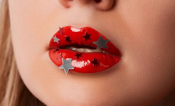 Chiudi macro donne paffuto labbra con brillantezza rossa e stelle d'argento. Bellezza ritratto di moda trucco personale - Foto, immagini