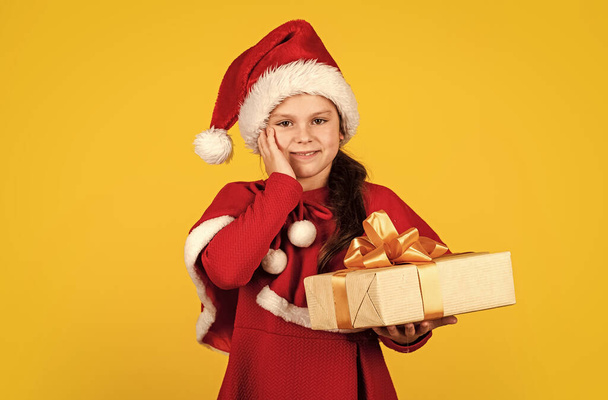 Great gift. big christmas sale. child santa hat hold gift box. boxing day concept. all i dream about. happy new year. winter holiday and xmas joy. seasonal shopping discount. small girl carry present - 写真・画像