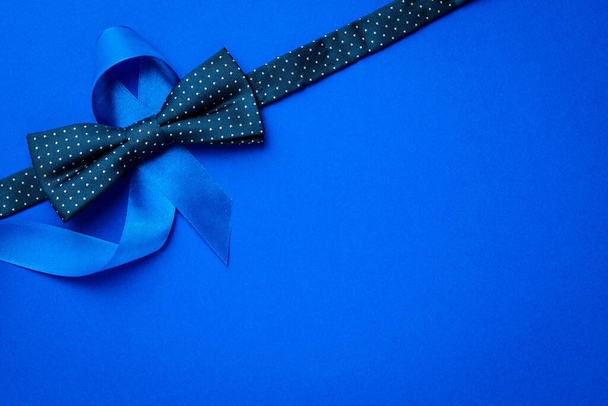 Modrá prostata. Informovanost rakovina prostaty u mužů zdraví v listopadu. Modrá stuha, módní motýlek izolovaný na tmavomodrém pozadí. November and International Mens Day - Fotografie, Obrázek