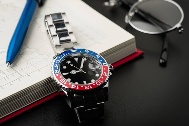 primer plano reloj de pulsera de lujo para hombres con esfera negra bisel azul-rojo y brazalete de acero. - Foto, Imagen