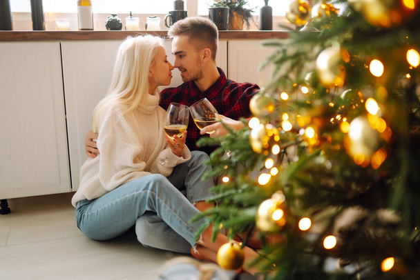 Young couple together celebrating christmas at decorated home.  Romantic day. Winter holidays. - 写真・画像