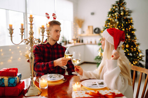 Young couple together celebrating christmas at decorated home.  Romantic day. Winter holidays. - Zdjęcie, obraz