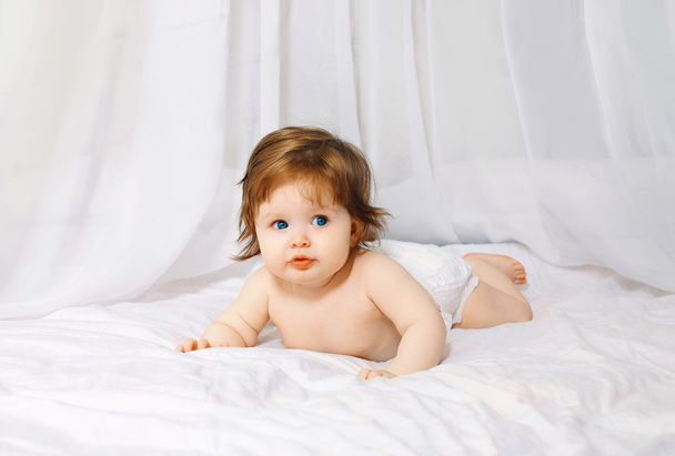 Charming baby on the bed home - Фото, изображение