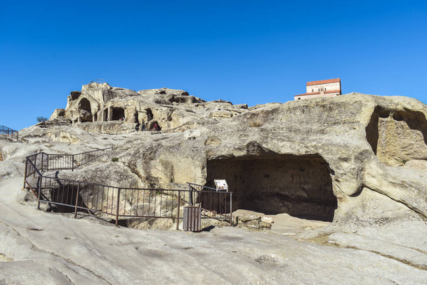 Uplistsikhe, Gori, Gürcistan - 23 Ekim 2021 Gori yakınlarındaki Uplistsikhe mağara kompleksi. Kayanın üzerinde üç katmanlı bazilika. Antik kaya yontulmuş kasaba. Gürcistan Gourist simgesi. - Fotoğraf, Görsel