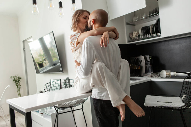 Couple aimant s'embrassent dans la cuisine. Un concept romantique et amoureux. mode de vie photo - Photo, image