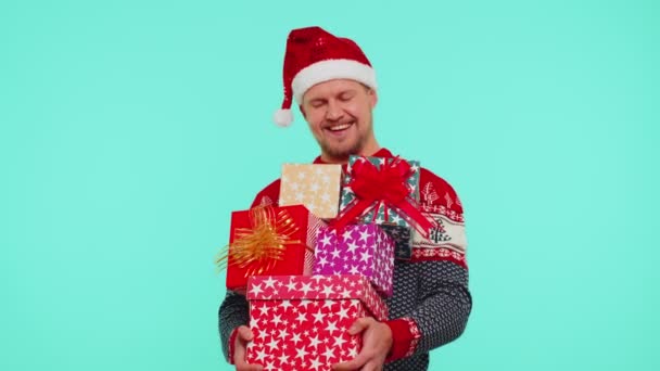 Fešák stylový muž ve vánočním svetru drží mnoho dárkových krabic Nový rok představuje nákupní prodej - Záběry, video