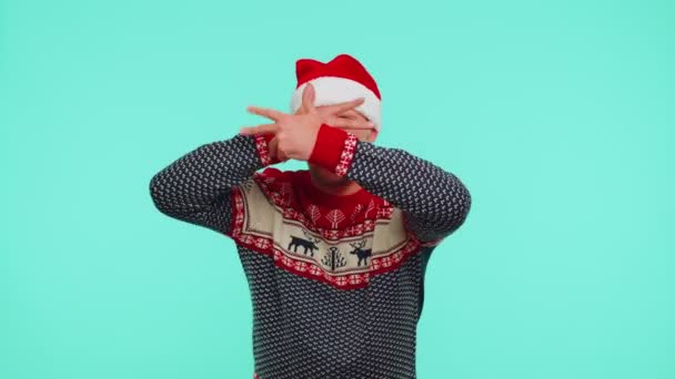 Hullu mies villapaidassa Joulupukin jouluhattu osoittaa kielensä ulos, pelleillä ympäriinsä tekemässä typeriä kasvoja - Materiaali, video