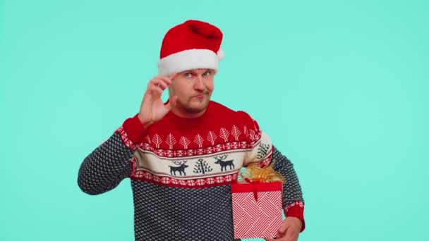 クリスマス・セーターの男がカメラを指差す愚かなジェスチャーを見せ計画のためにバカを非難 - 映像、動画