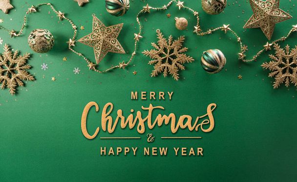 Рождество и Новый год фон концепция. Вид сверху на рождественский шар, звезду и золотую снежинку на зеленом фоне. - Фото, изображение