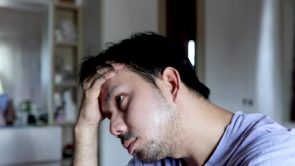 Nieszczęśliwy Azjata cierpiący na stres i bóle głowy w domu - Materiał filmowy, wideo