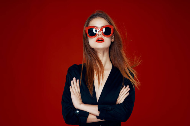 pretty woman wearing sunglasses fashion posing hairstyle red background - 写真・画像