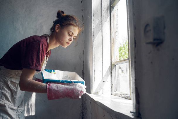 woman painter paints window with brush renovation interior decoration - Valokuva, kuva