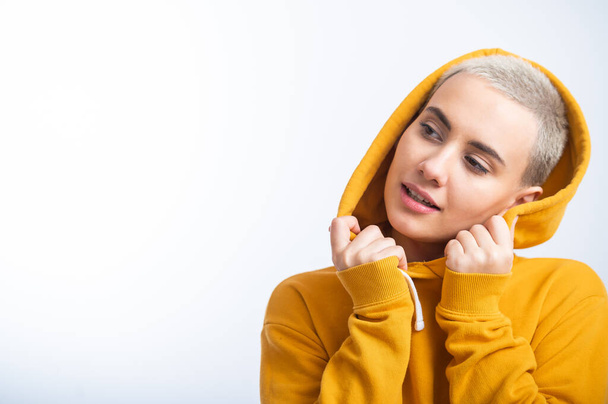 Young woman in an ocher hood on a white background. - Foto, Bild