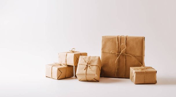 Подарки в экологически чистой бумажной упаковке на белом фоне. Копирование концепции пространства минимализма - Фото, изображение