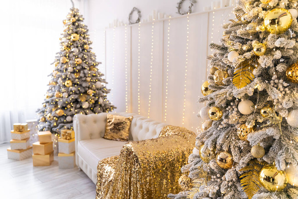 White living room interior with New Year tree decorated, present boxes and white sofa. Colden colors  - Φωτογραφία, εικόνα