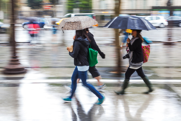 People in motion blur walking in the rainy city - Valokuva, kuva