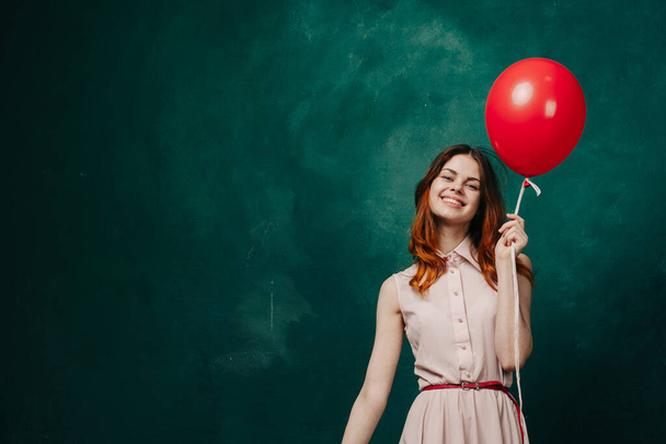cheerful woman with red balloon green background holiday - Foto, afbeelding