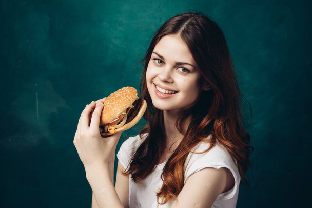 cheerful woman eating hamburger snack close-up lifestyle - Foto, afbeelding