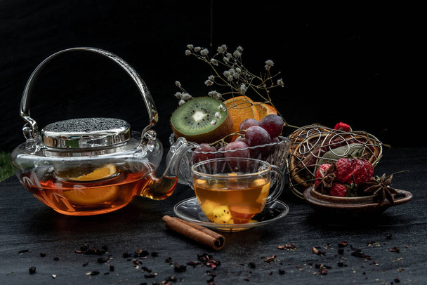 Glass of freshly brewed fruit and herbal tea. Darker background. - Fotoğraf, Görsel