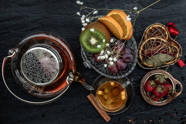 Glass of freshly brewed fruit and herbal tea. Darker background. Top view. - Fotó, kép