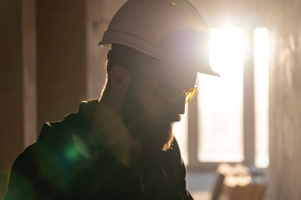 Portrait d'un constructeur masculin portant un casque et des lunettes de protection. - Photo, image