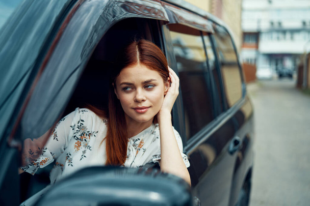 cheerful woman driving a car looks out of the window - Foto, Imagen