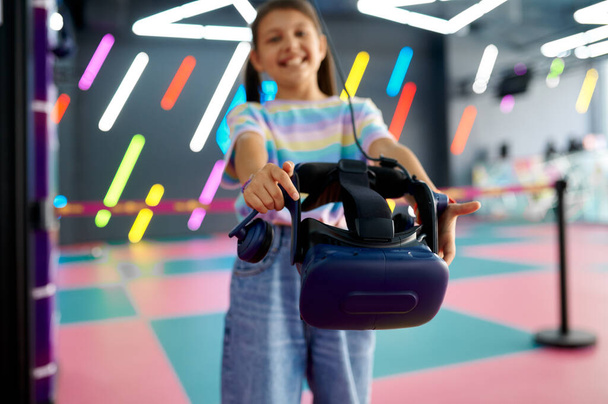 Vrolijk klein meisje houdt virtual reality bril - Foto, afbeelding
