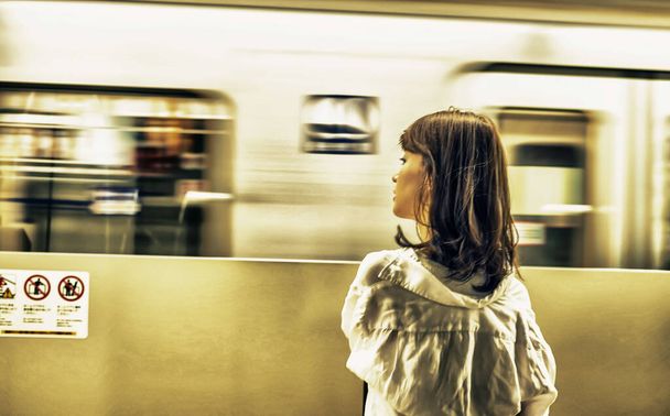 Asijské dívka čeká na příjezd vlaku ve stanici metra. - Fotografie, Obrázek